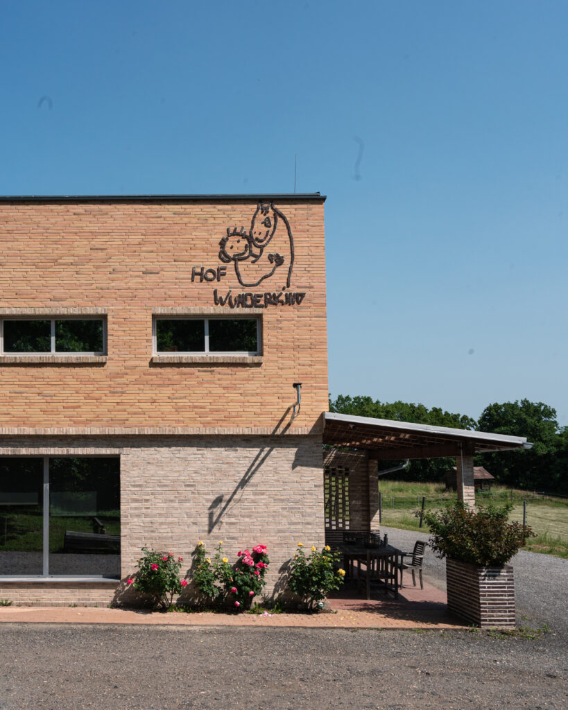 Hof Wunderkind, Klinkergebäude mit Logo an der Wand